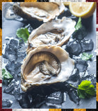 Oysters on ice with lemon wedges and parsley on a dark surface