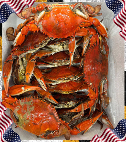 A top-down view of cooked red crabs piled inside a white styrofoam box, with American flag graphics framing the corners.