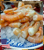 Shrimp on ice in a blue and white container with an American flag in the corner.